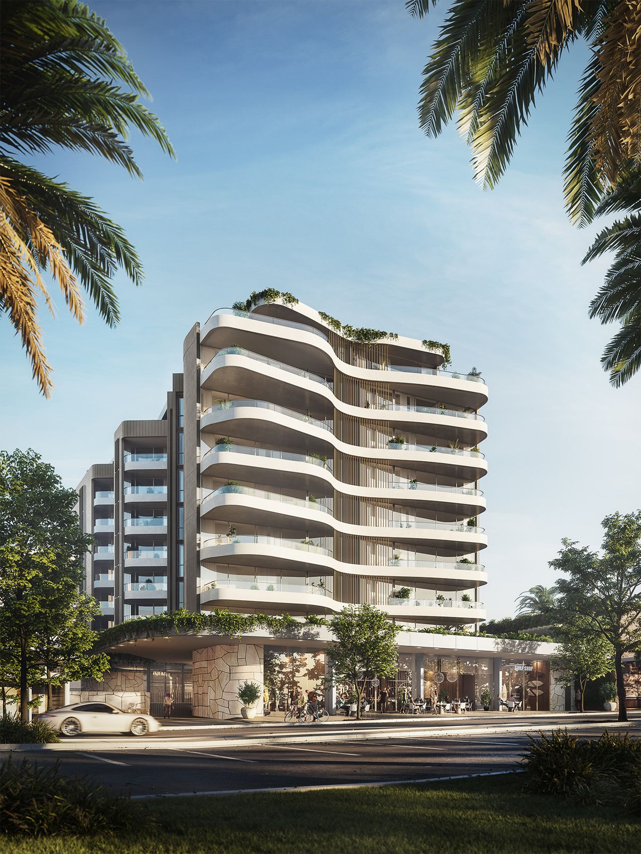 Curved coastal apartment building framed by palms